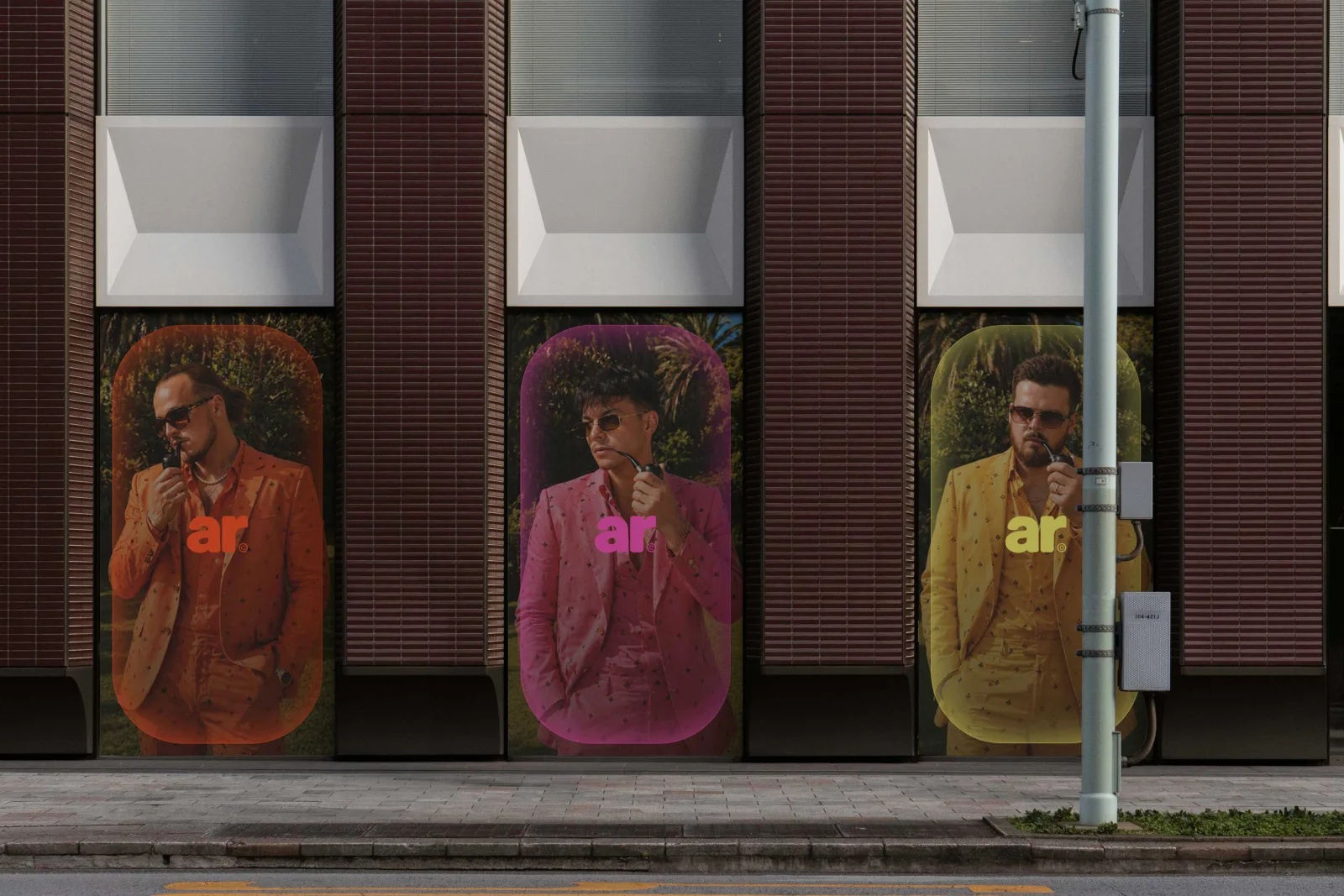 Trois affiches Agence Rose, orange, rose et jaune, sur la façade d'un immeuble